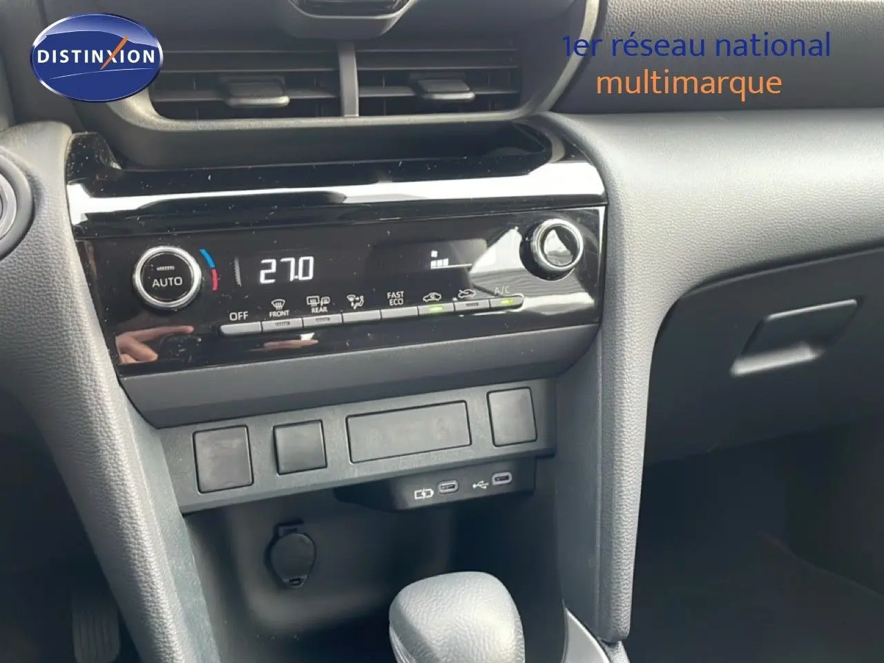 Vue rapprochée du tableau de bord et console centrale noire de la Toyota Yaris Cross 1.5 Hybrid 2024 avec climatisation digitale.