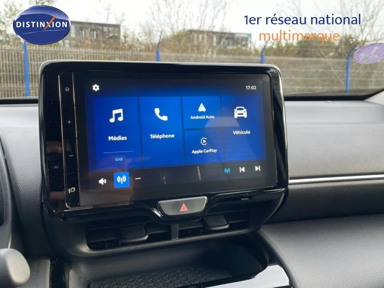 Écran tactile central de la Toyota Yaris Cross blanc pur, vue de face sur le tableau de bord avec interface multimédia visible.