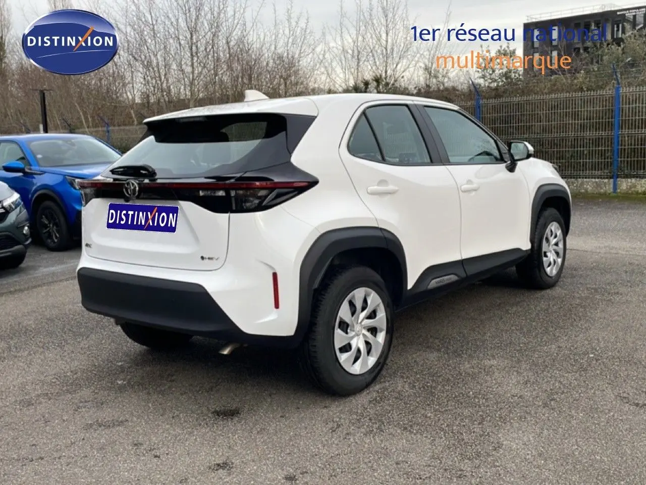 Vue 3/4 arrière droite d'une Toyota Yaris Cross blanche Pure avec détails noirs et feux arrière allongés.