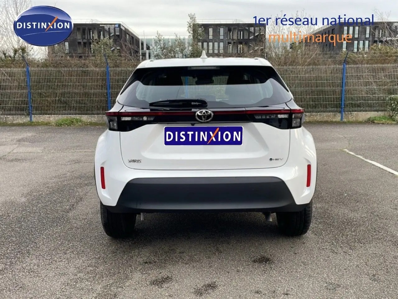 Vue arrière d'une Toyota Yaris Cross 1.5 Hybrid blanc pur, avec feux arrière étirés et pare-chocs noir contrastant.