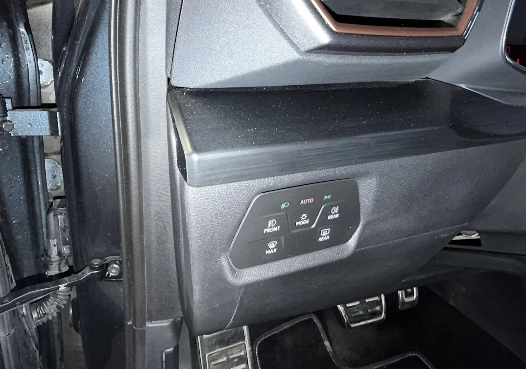 Détail du tableau de bord côté gauche d'une CUPRA Formentor gris clair, avec commandes d'éclairage et pédales sport en aluminium.