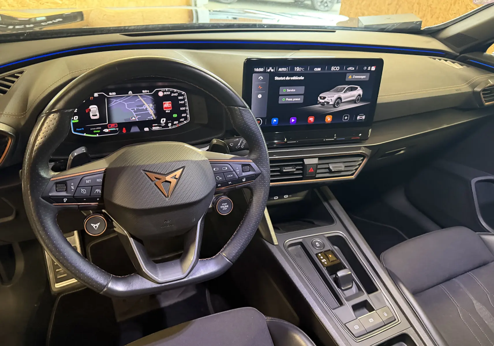 Vue intérieure du tableau de bord et volant super sport noir de la CUPRA Formentor 1.4 Hybrid 245 DSG6 avec écran tactile central allumé.