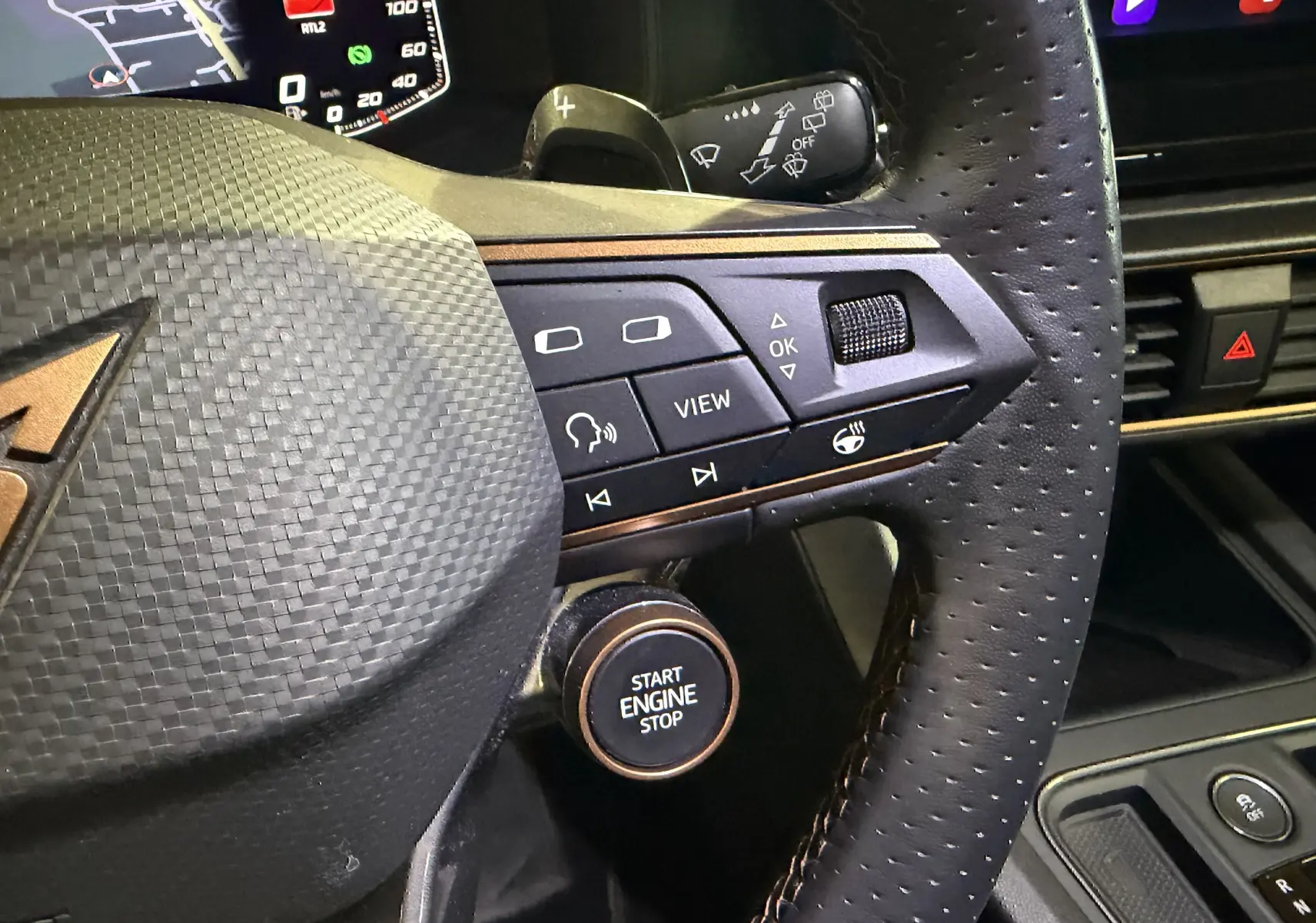 Gros plan sur le volant perforé noir avec commandes intégrées et bouton start/stop cuivré du CUPRA Formentor gris clair 2023.