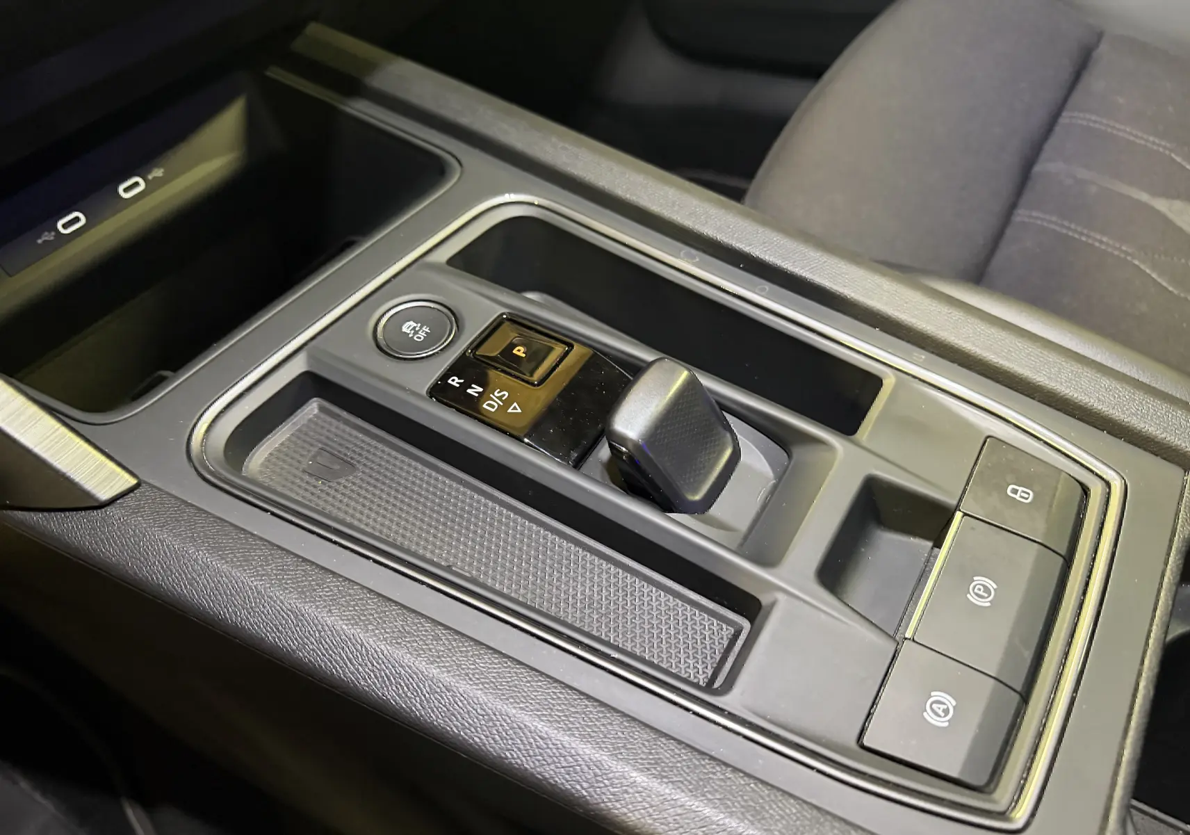 Gros plan sur la console centrale de la CUPRA Formentor hybride 2023, avec levier de vitesses automatique et boutons de contrôle.