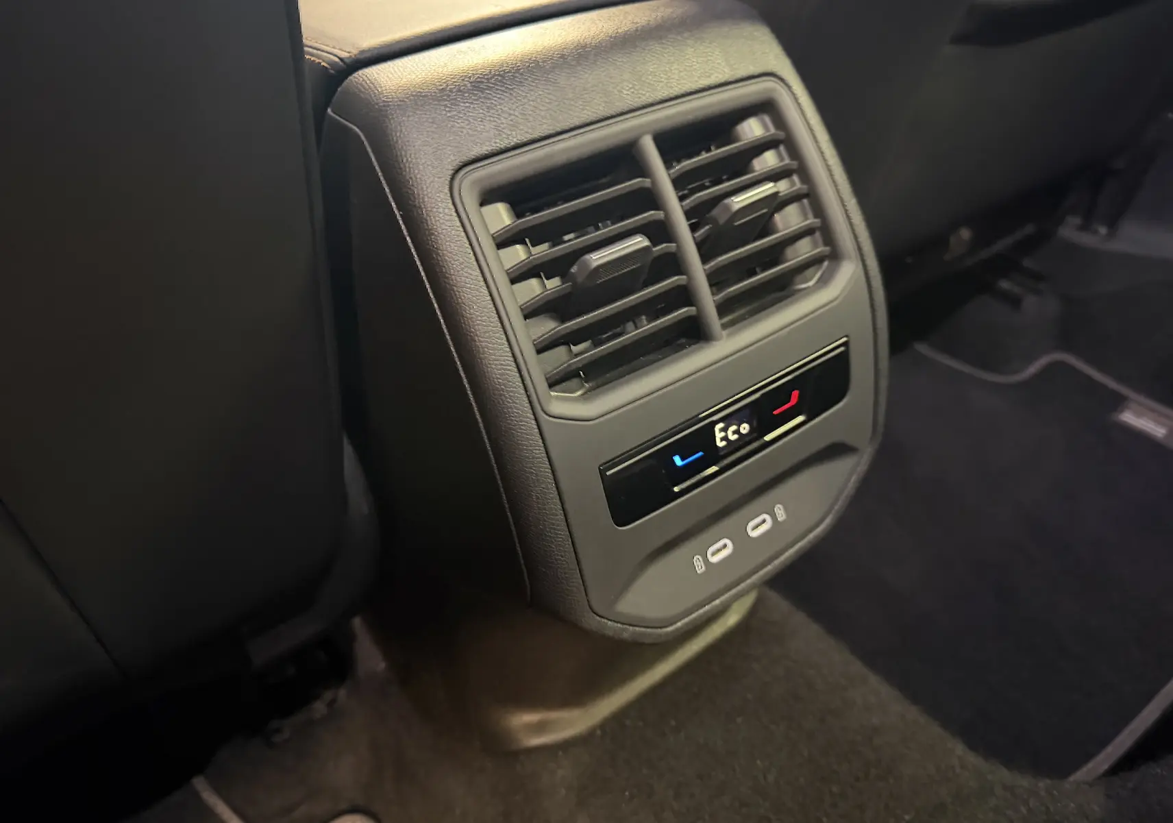 Vue rapprochée de la console arrière noire du CUPRA Formentor 1.4 Hybrid 2023 avec commandes climatisation et ports USB.