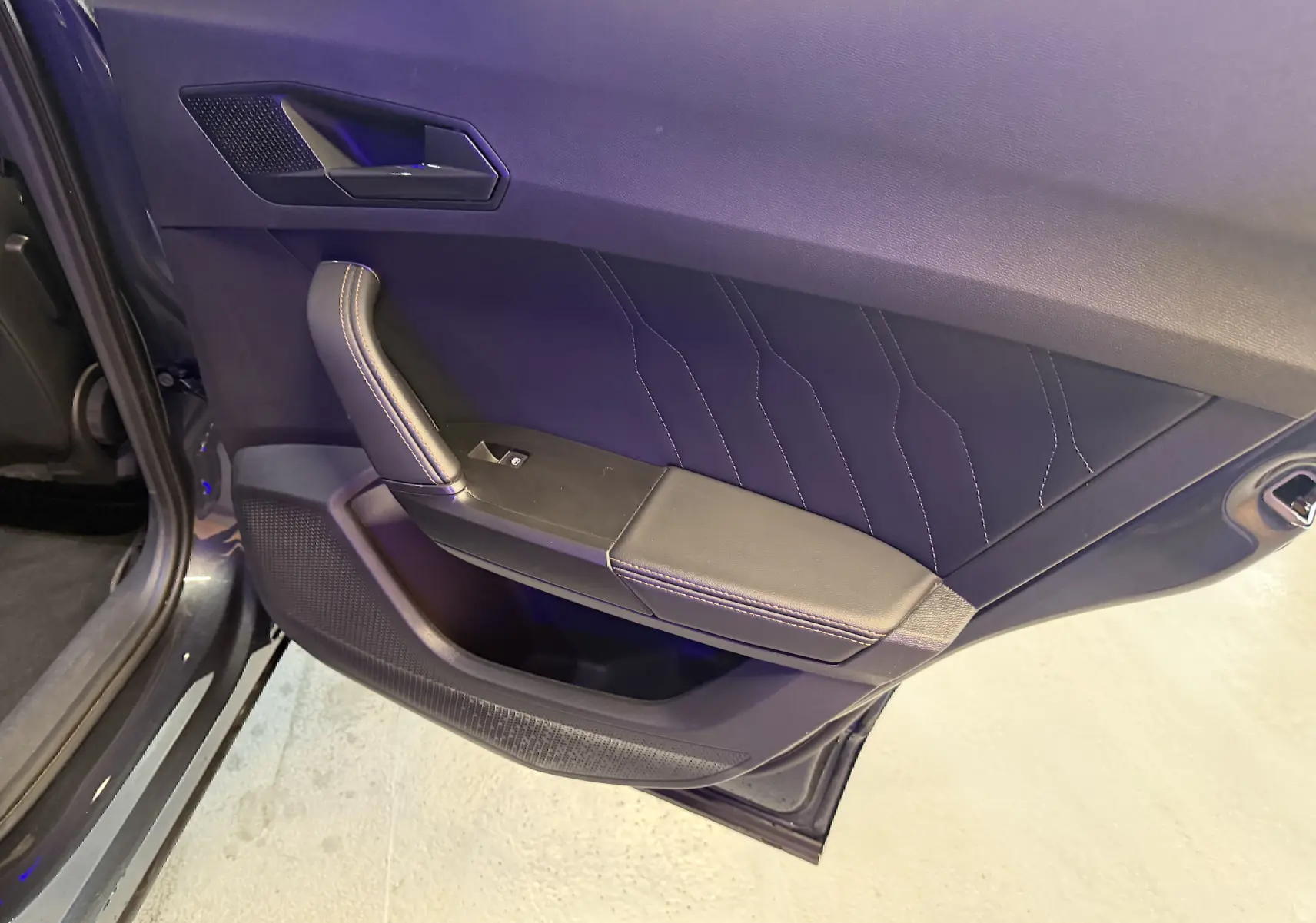 Vue rapprochée de la porte arrière gauche gris clair du CUPRA Formentor 1.4 Hybrid 245 avec surpiqûres décoratives.