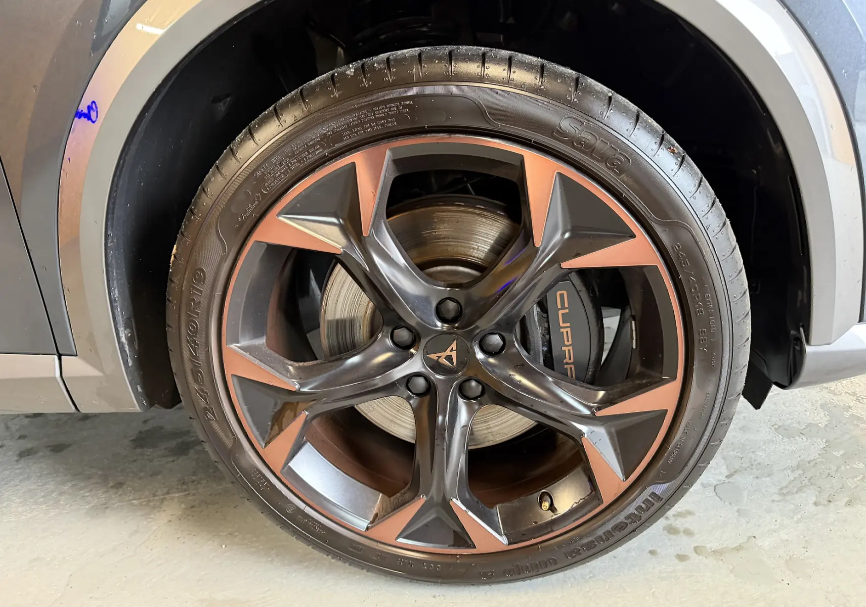 Gros plan sur la jante cuivrée et noire du côté gauche d’un CUPRA Formentor gris clair 2023 avec logo central distinctif.