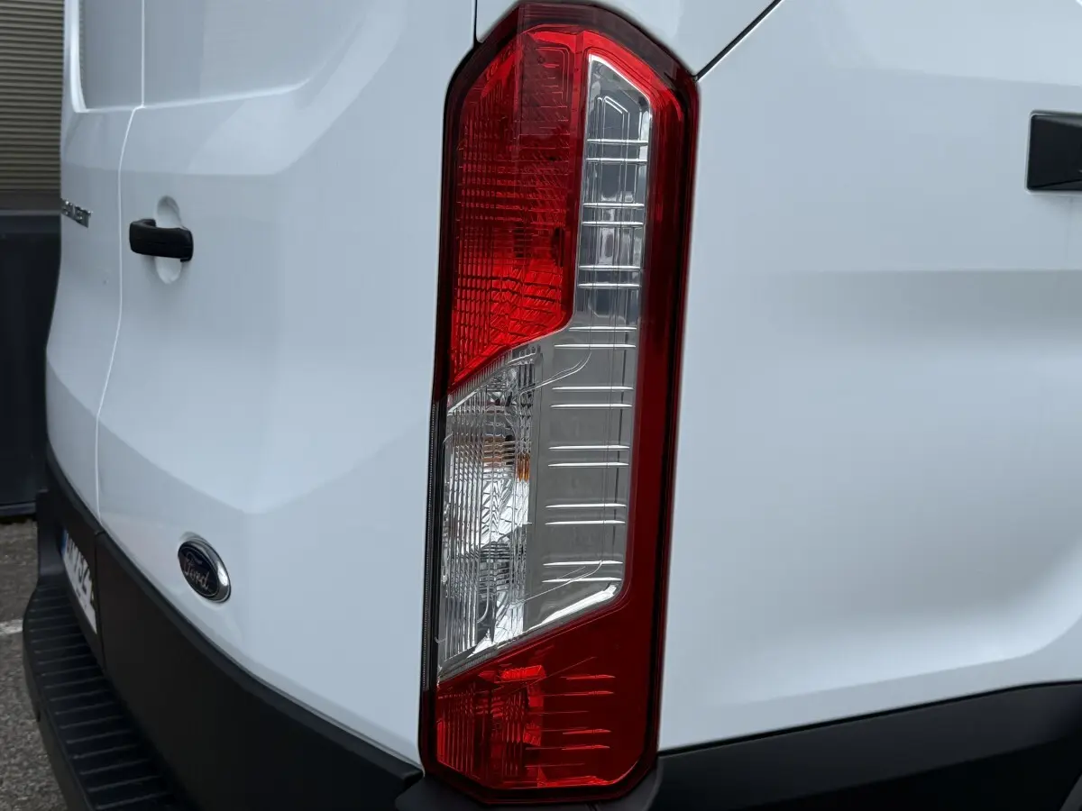 Gros plan sur le feu arrière droit du Ford Transit Fourgon blanc, avec logo Ford visible sur la porte arrière.