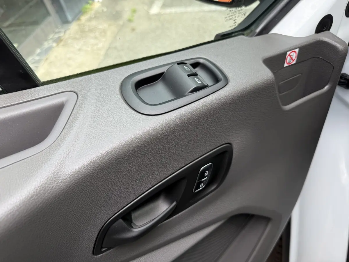 Détail de la porte côté conducteur du Ford Transit Fourgon blanc 2024 avec commandes de vitres et verrouillage.