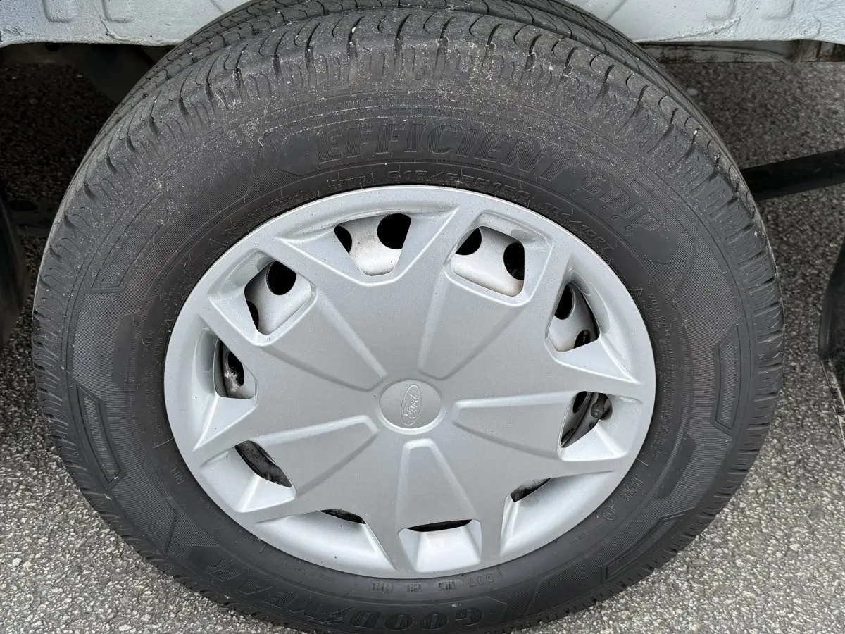 Gros plan sur la roue avant droite du Ford Transit Fourgon blanc, avec enjoliveur gris et pneu Goodyear.