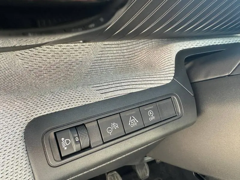 Vue intérieure détaillée du panneau de commandes côté conducteur de la Citroën C3 2025 en tissu noir et motifs gris.