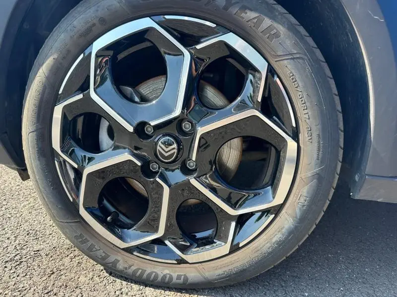 Gros plan sur la roue avant droite d'une Citroën C3 2025 Bright Blue avec toit noir, sur sol asphalté.