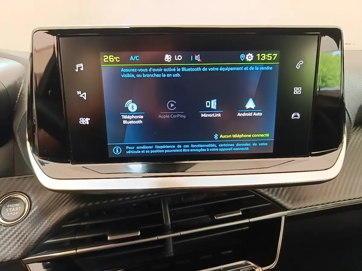 Écran tactile central du tableau de bord du Peugeot E-2008 gris clair, affichant les options Bluetooth et Android Auto.