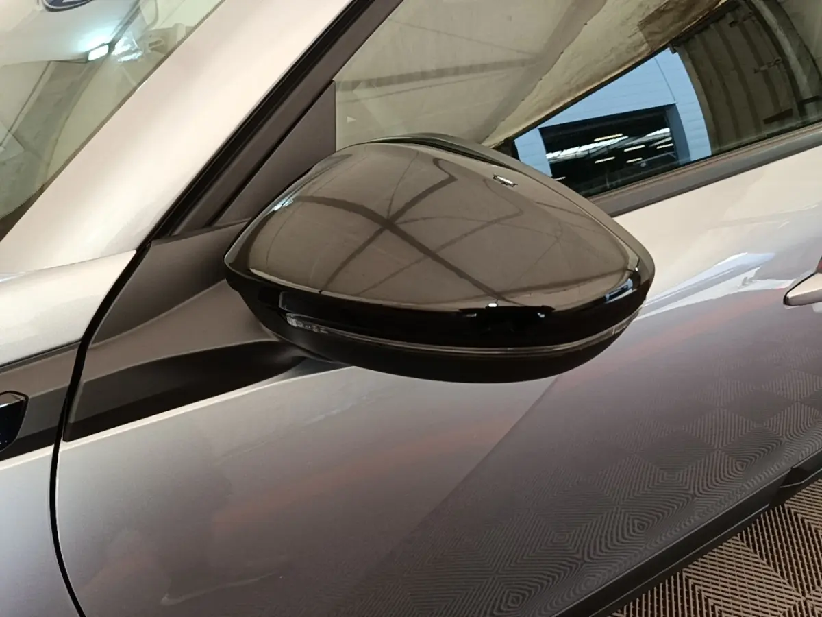Rétroviseur noir en gros plan côté gauche sur Peugeot E-2008 électrique gris clair 2023.