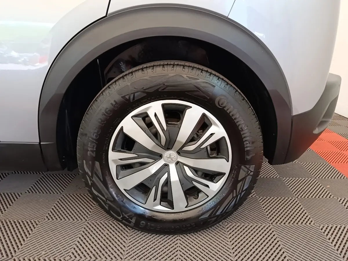 Gros plan sur la roue arrière droite gris clair du Peugeot E-2008 électrique avec jante alliage et pneu Continental.