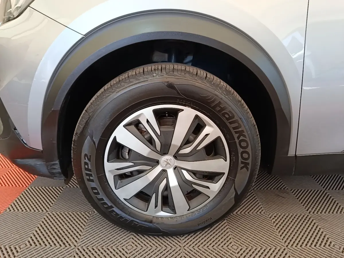 Gros plan sur la roue avant gauche d’un Peugeot E-2008 électrique gris clair avec jante spécifique et pneu Hankook.