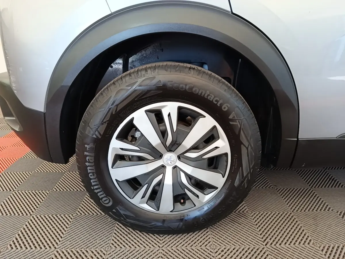 Gros plan sur la roue avant gauche gris clair du Peugeot E-2008 électrique avec jante en alliage et pneu Continental.