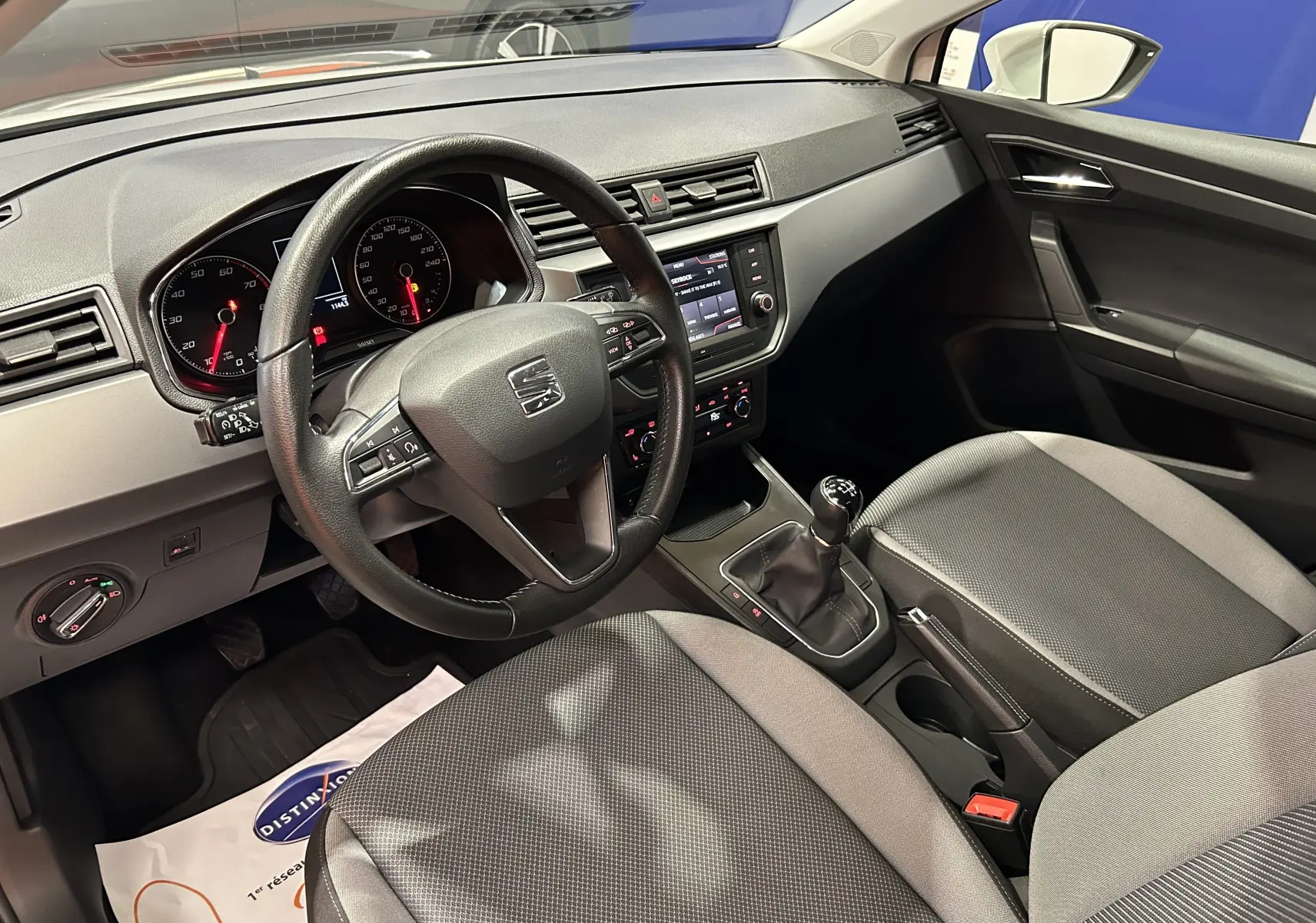 Intérieur de la SEAT Ibiza 2019 vu côté conducteur, volant multifonction et sièges tissu gris avec boîte manuelle.