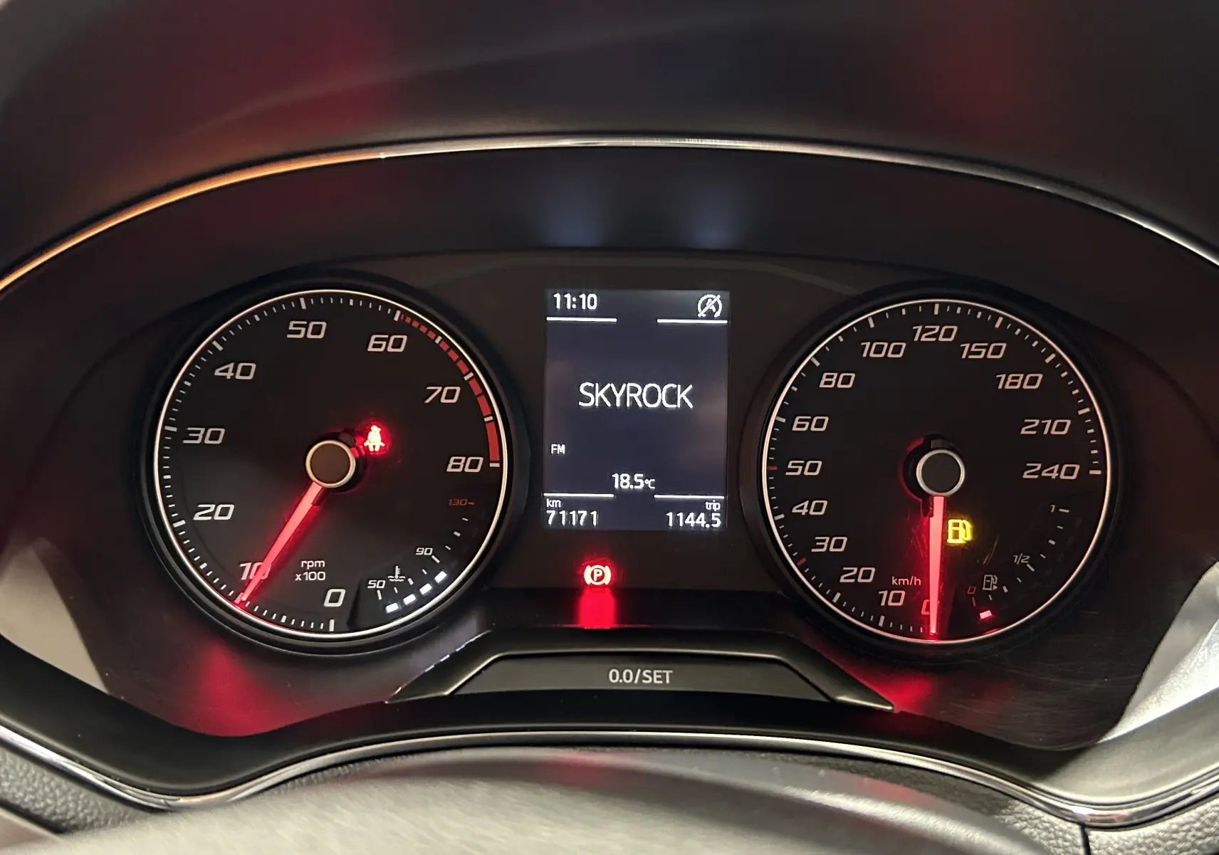 Vue rapprochée du tableau de bord de la SEAT Ibiza blanche 2019, affichant la radio Skyrock et les compteurs rpm et vitesse.