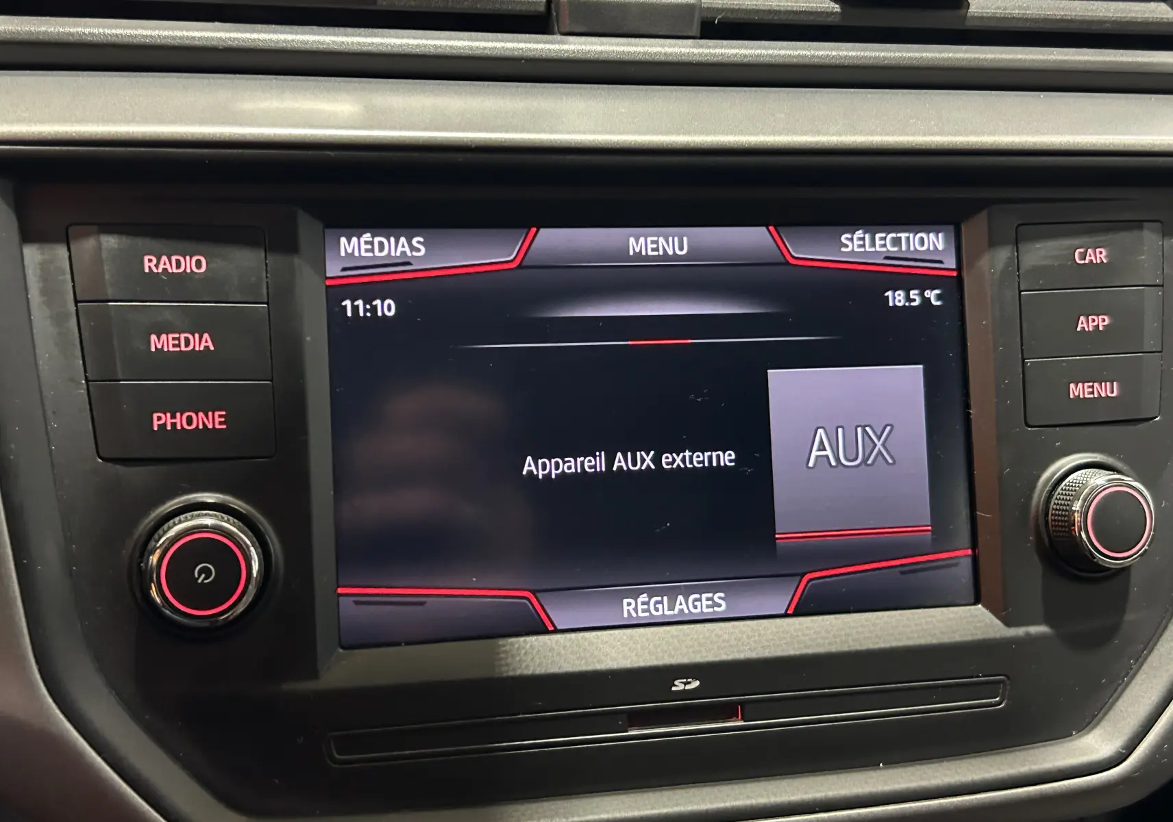 Écran multimédia de la SEAT Ibiza 2019 montrant la connexion d’un appareil AUX externe, avec boutons de contrôle autour.