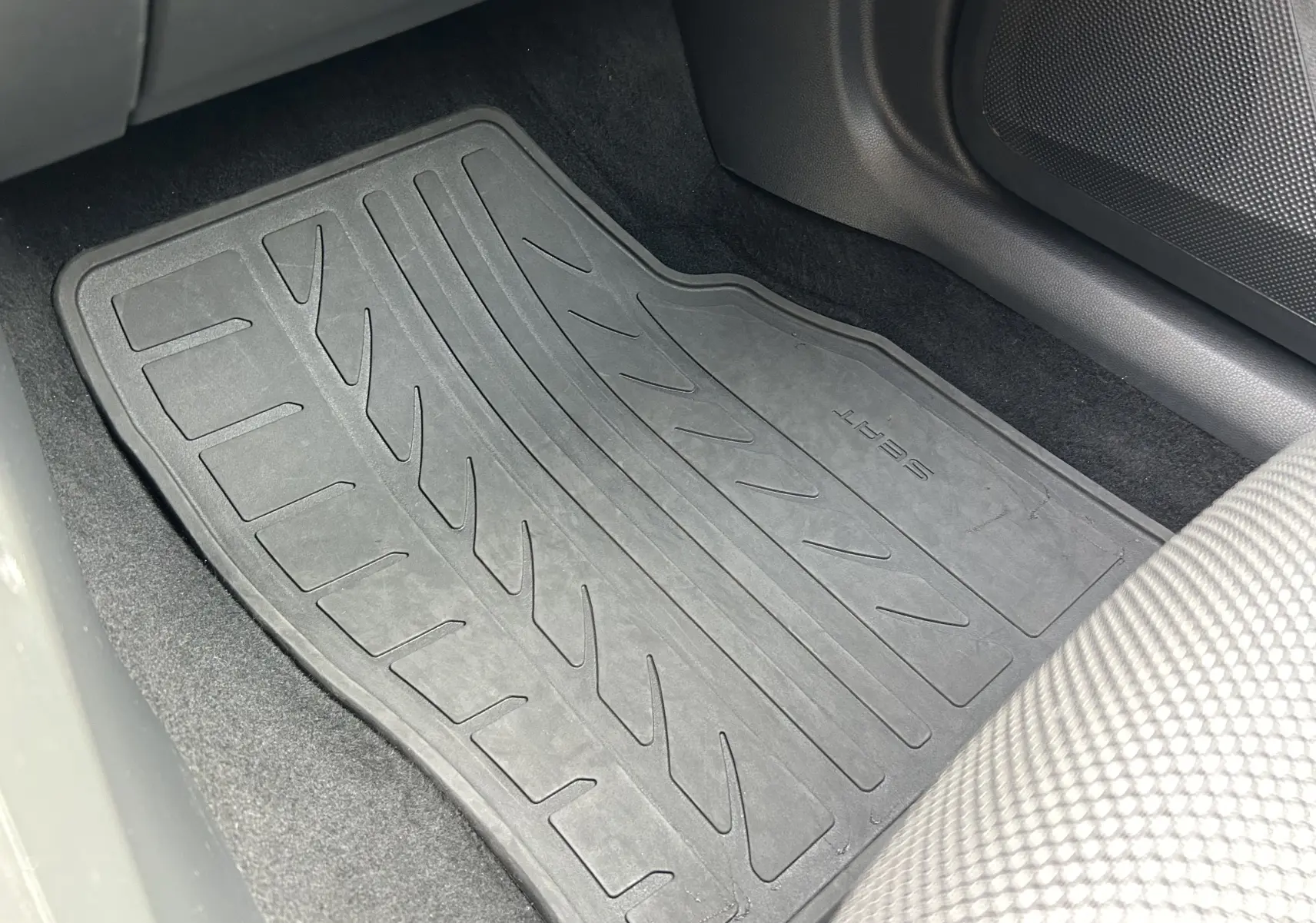 Tapis de sol noir marqué SEAT côté passager avant d'une Ibiza blanche 2019, intérieur tissu gris.
