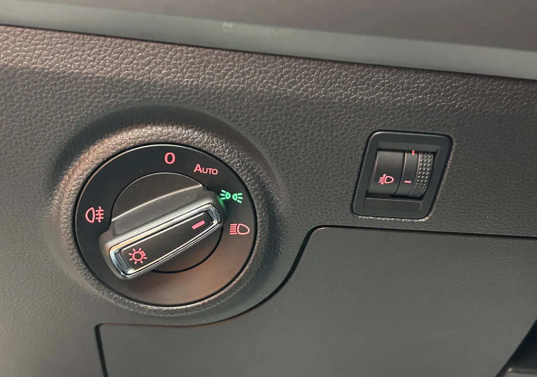 Gros plan sur la commande d'éclairage et le réglage de hauteur des phares dans une SEAT Ibiza blanche 2019.