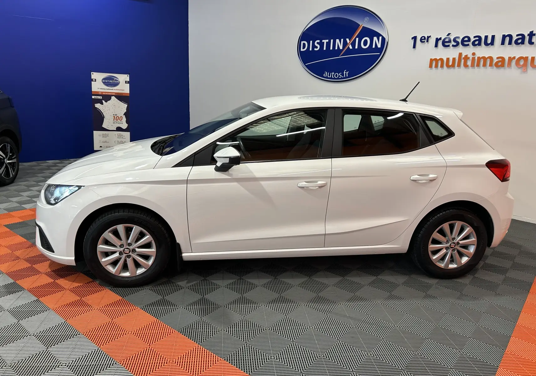 Profil côté gauche d'une SEAT Ibiza blanche 2019 en finition Style, exposée en showroom avec jantes alliage.