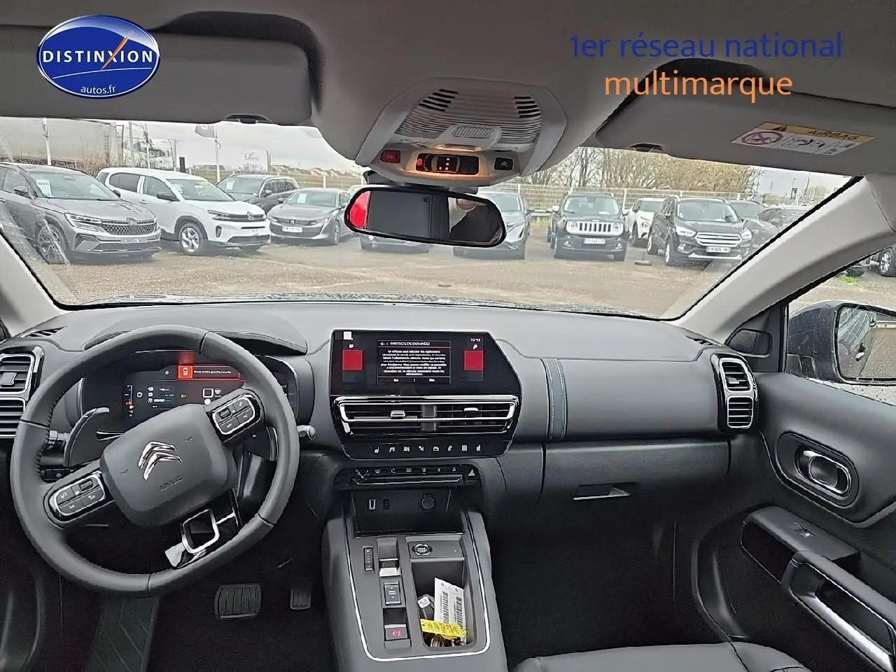 Vue intérieure avant du Citroën C5 Aircross 2025, tableau de bord noir avec écran tactile et volant multifonction.