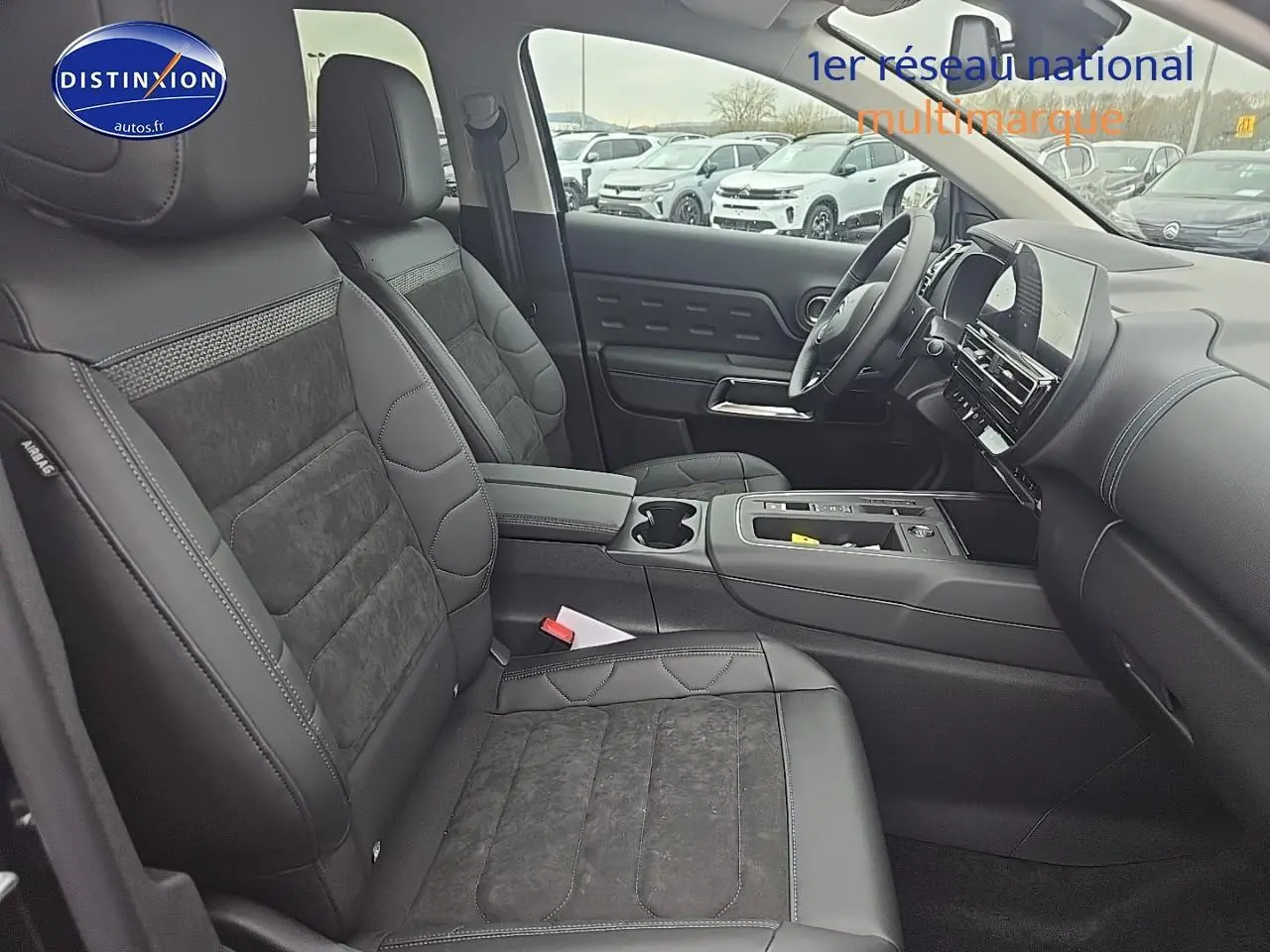 Intérieur du Citroën C5 Aircross 2025 vu côté passager, sièges noirs en cuir et alcantara avec console centrale moderne.