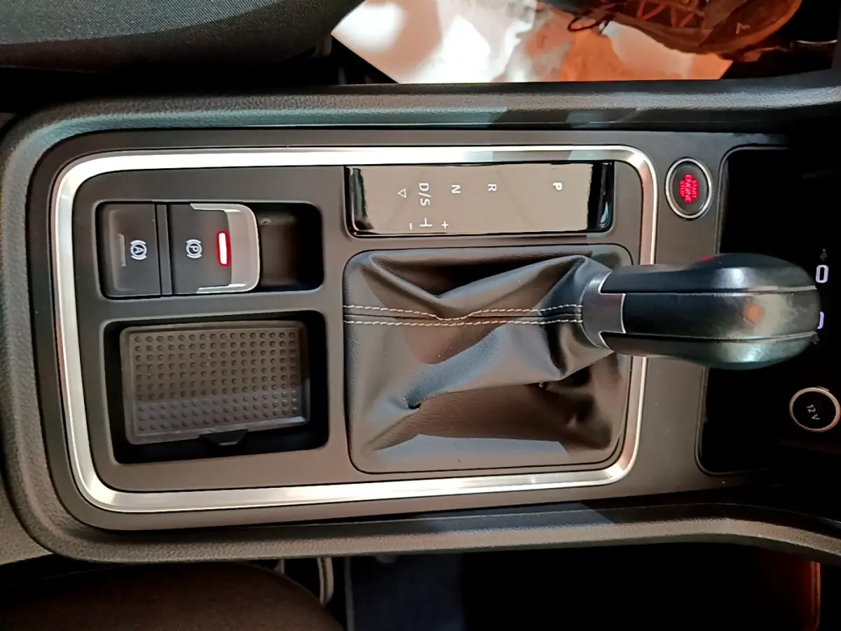 Vue rapprochée de la console centrale noire du SEAT Ateca 2022 avec levier de vitesses automatique et bouton démarrage rouge.