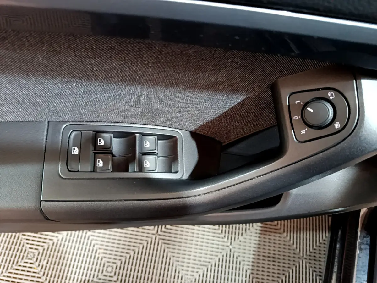 Commande des vitres et réglage des rétroviseurs côté conducteur du SEAT Ateca noir 2022, intérieur tissu et plastique noir.