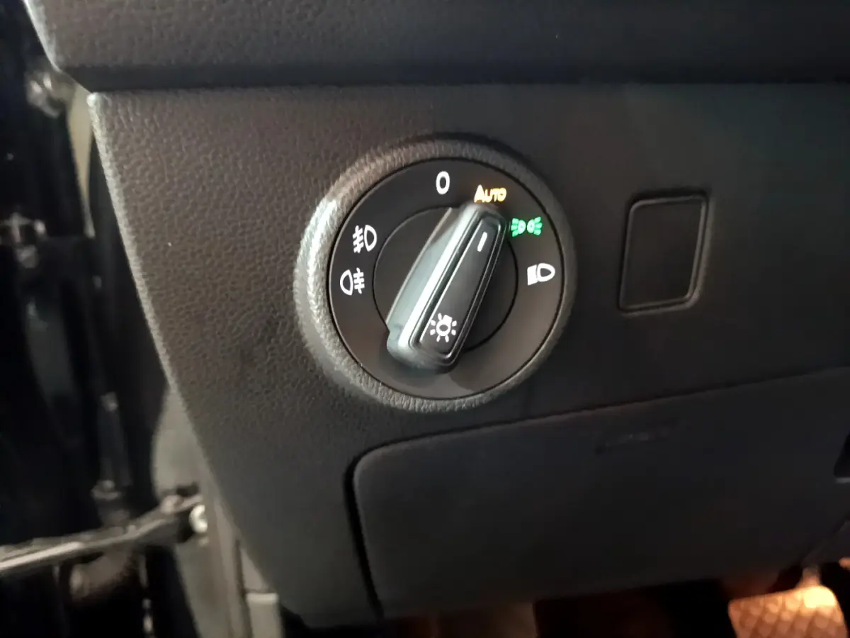 Gros plan sur le bouton de commande des phares du tableau de bord d'un SEAT Ateca noir 2022.