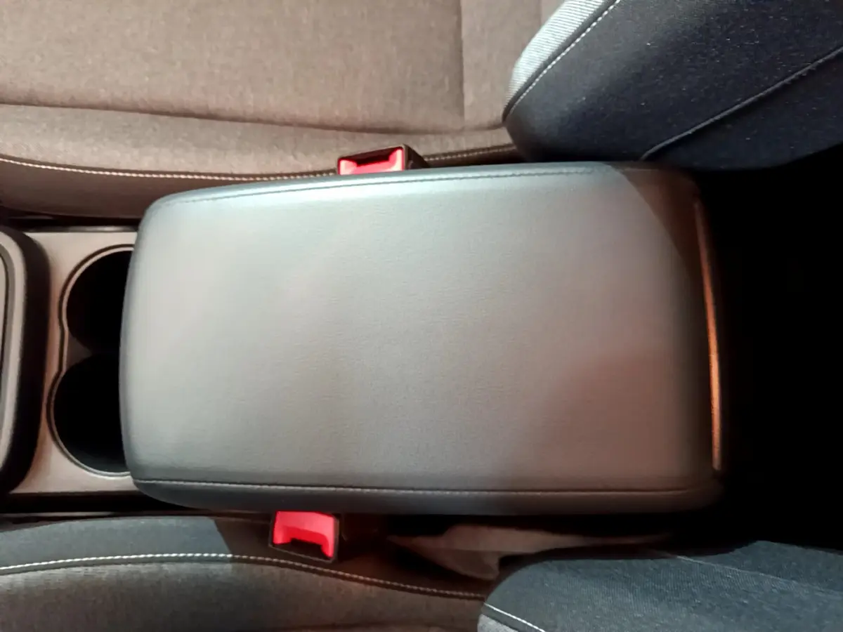 Vue rapprochée du couvercle de la console centrale noire entre les sièges avant du SEAT Ateca 2022.