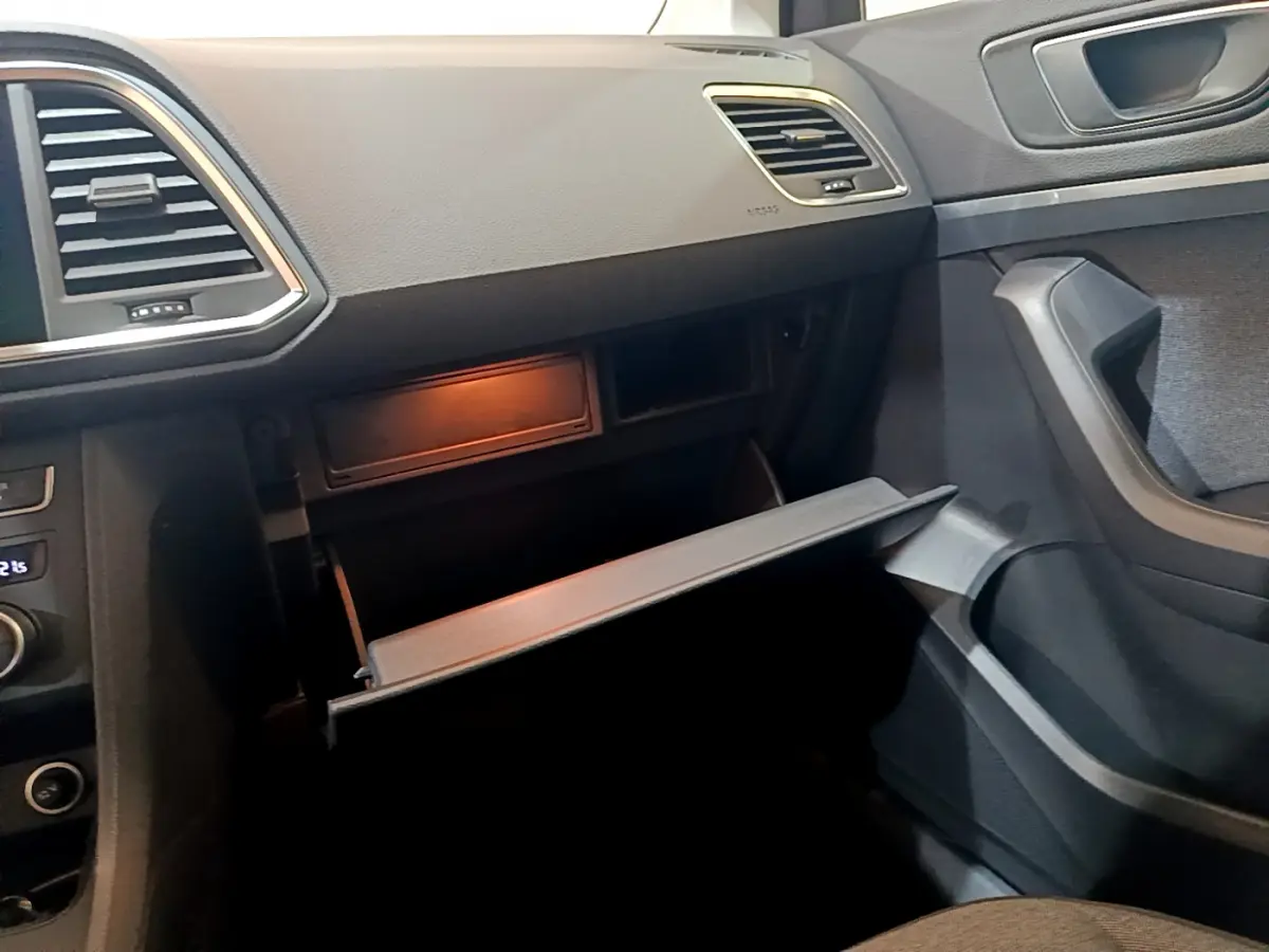 Intérieur SEAT Ateca 2022 vue côté passager, boîte à gants ouverte, tableau de bord noir et garnitures grises.