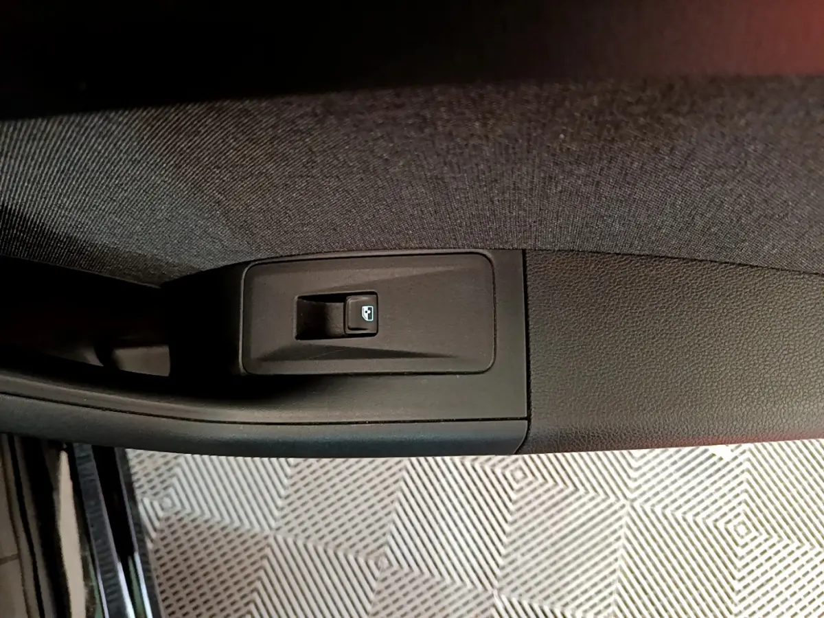 Bouton de commande de lève-vitre arrière droit sur la porte intérieure d'un SEAT Ateca noir 2022.