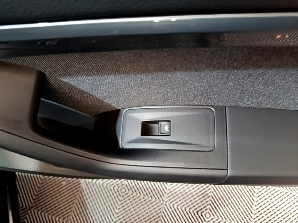 Gros plan sur le bouton de verrouillage des portes côté gauche intérieur d’un SEAT Ateca noir 2022.