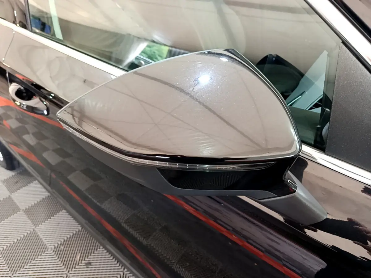 Rétroviseur côté gauche noir brillant du SEAT Ateca 2022 avec clignotant intégré, vue rapprochée en intérieur.