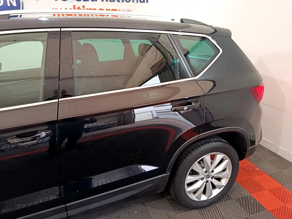 Vue latérale arrière droite du SUV SEAT Ateca noir avec jante alliage et vitres teintées.