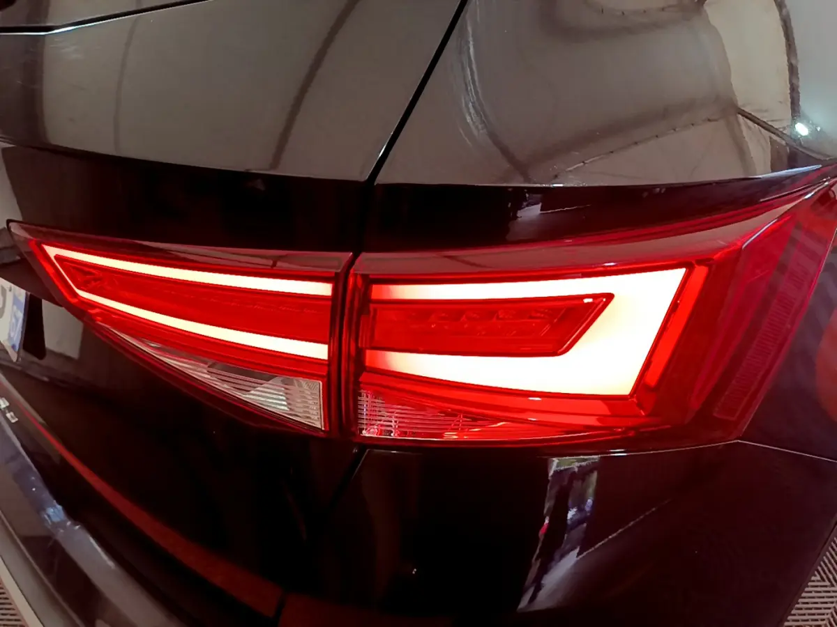 Gros plan sur le feu arrière droit allumé d'un SEAT Ateca noir 2022, soulignant ses lignes LED distinctives.