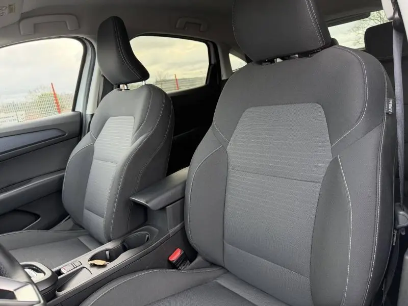 Vue intérieure rapprochée des sièges avant noirs du Renault Arkana 2025, avec accoudoir central et ceinture visible.