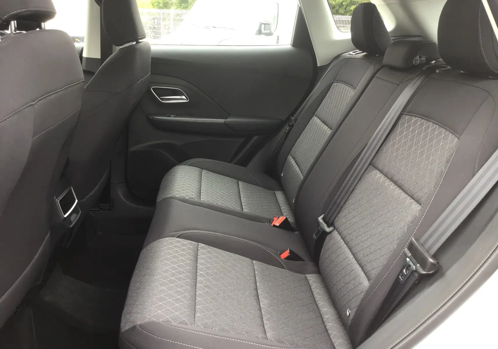 Vue intérieure côté droit des sièges arrière en tissu noir du MG ZS 1.5 L Hybrid+ 2026, avec ceintures et appuie-têtes visibles.