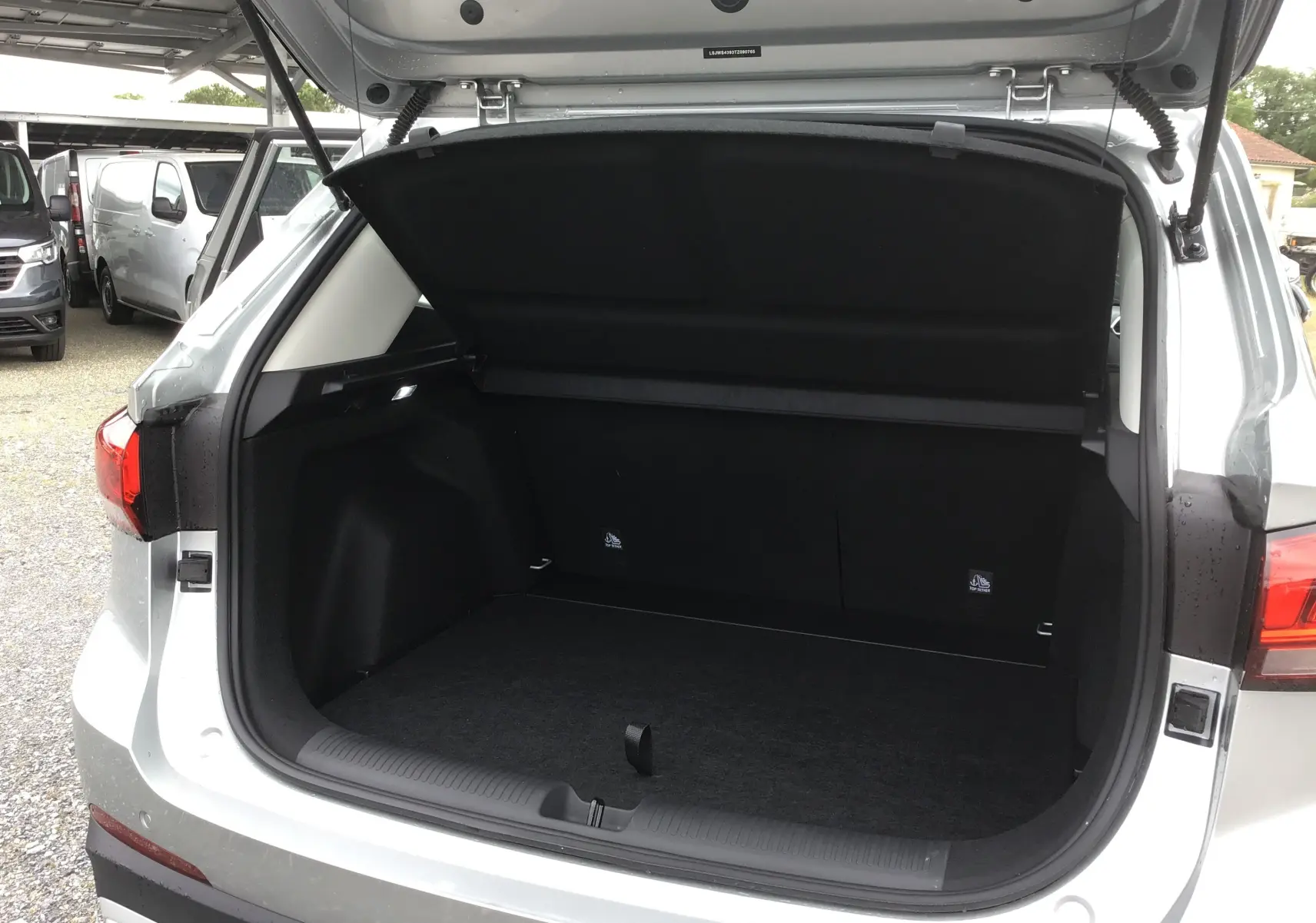 Coffre ouvert vu de l'arrière d'un MG ZS Cosmic Silver 2026, montrant l'espace de chargement vide et la trappe relevée.