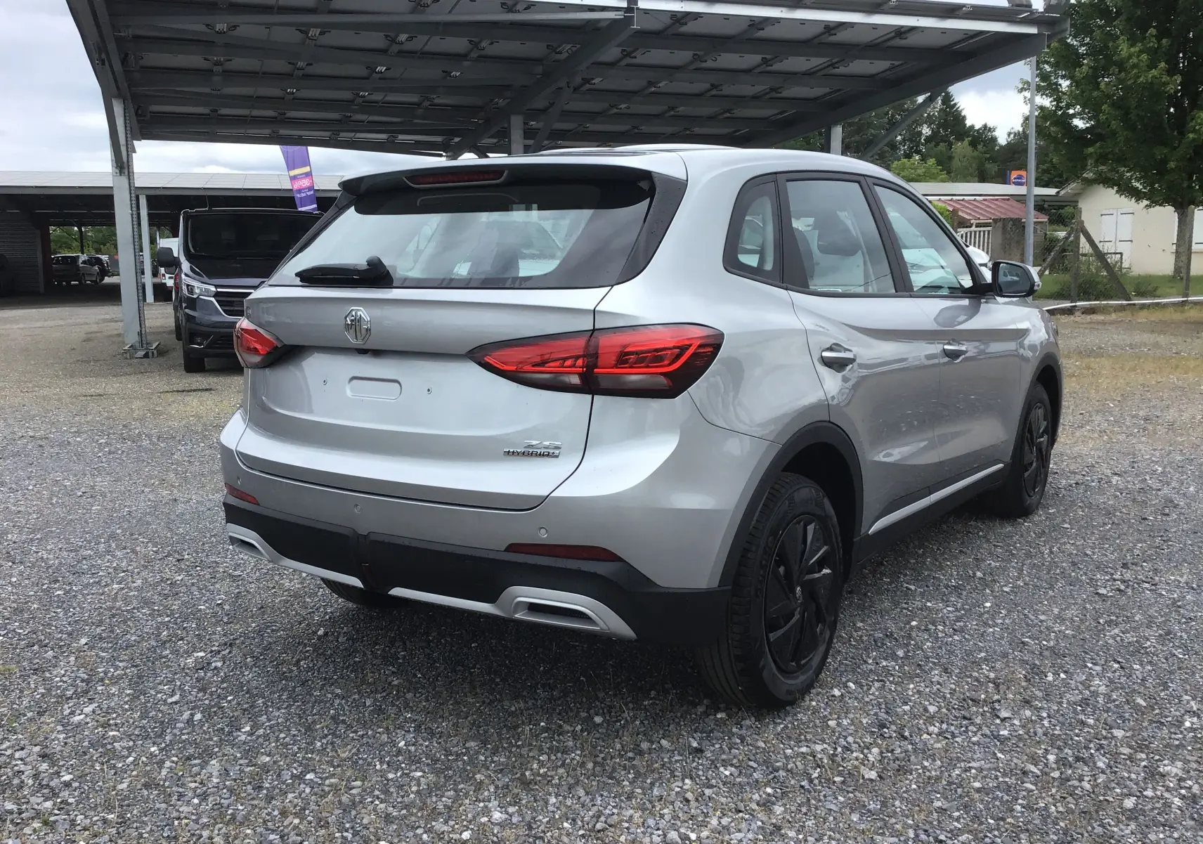 Vue 3/4 arrière droite du MG ZS Cosmic Silver avec feux arrière LED et jantes acier noires.