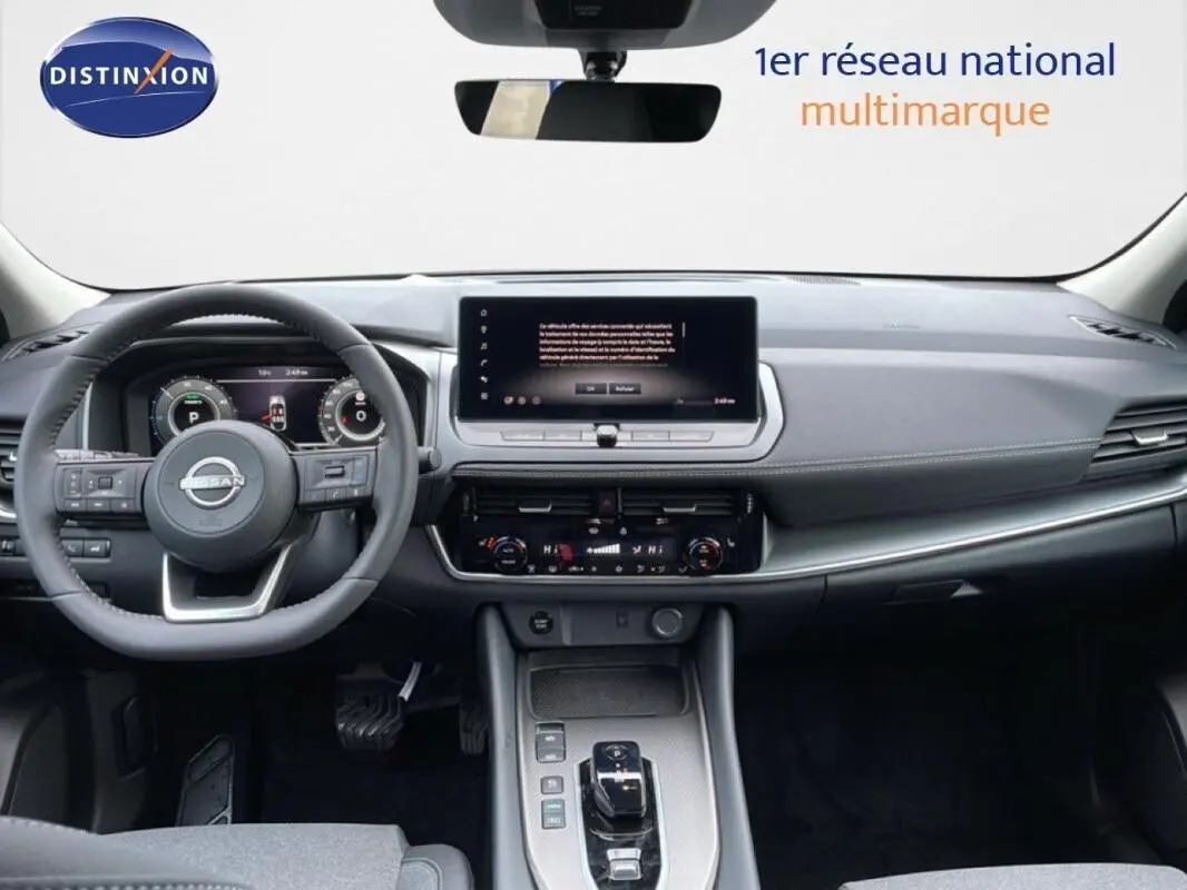 Intérieur du Nissan Qashqai 2025 gris, vue frontale du tableau de bord avec écran tactile et volant multifonctions cuir.