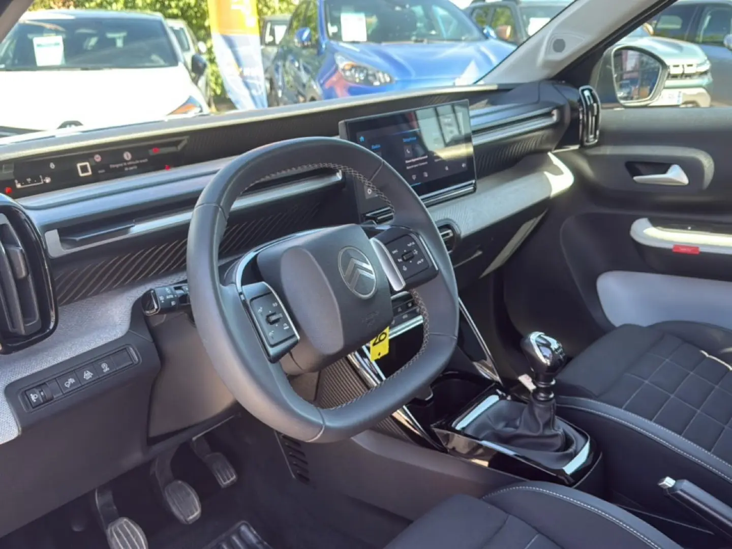 Intérieur de la Citroën C3 2025 vu côté conducteur, volant multifonctions et boîte manuelle en évidence.