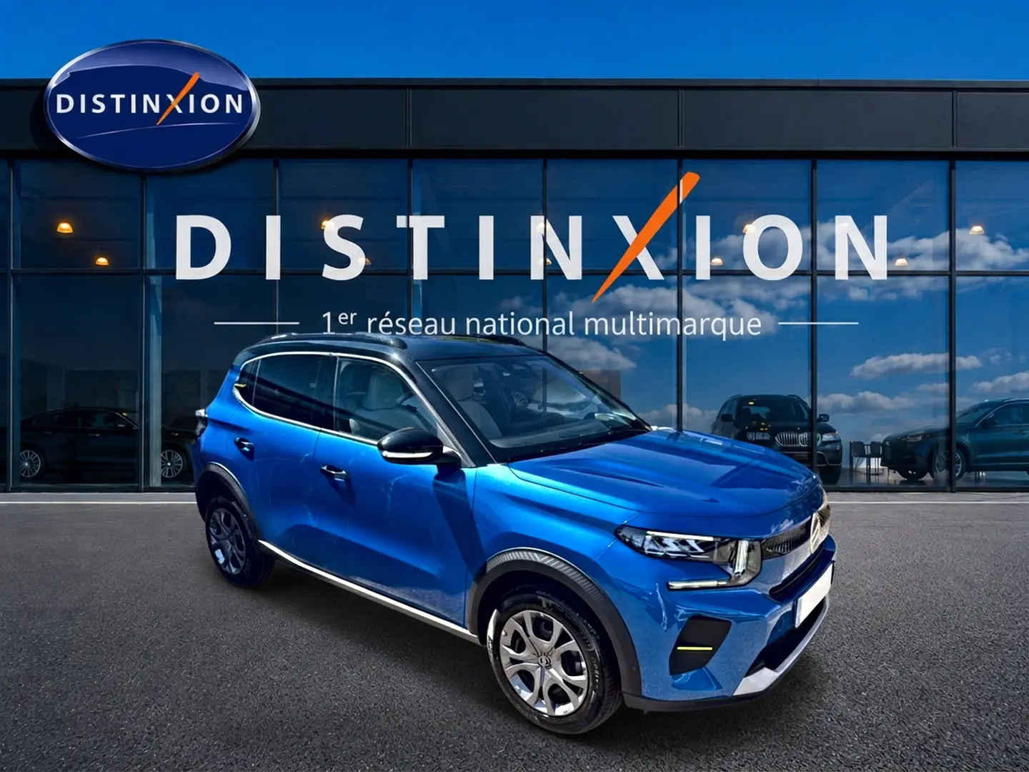Citroën C3 1.2 turbo bleu en 3/4 avant droit, avec toit noir et jantes alu devant showroom Distinxion.