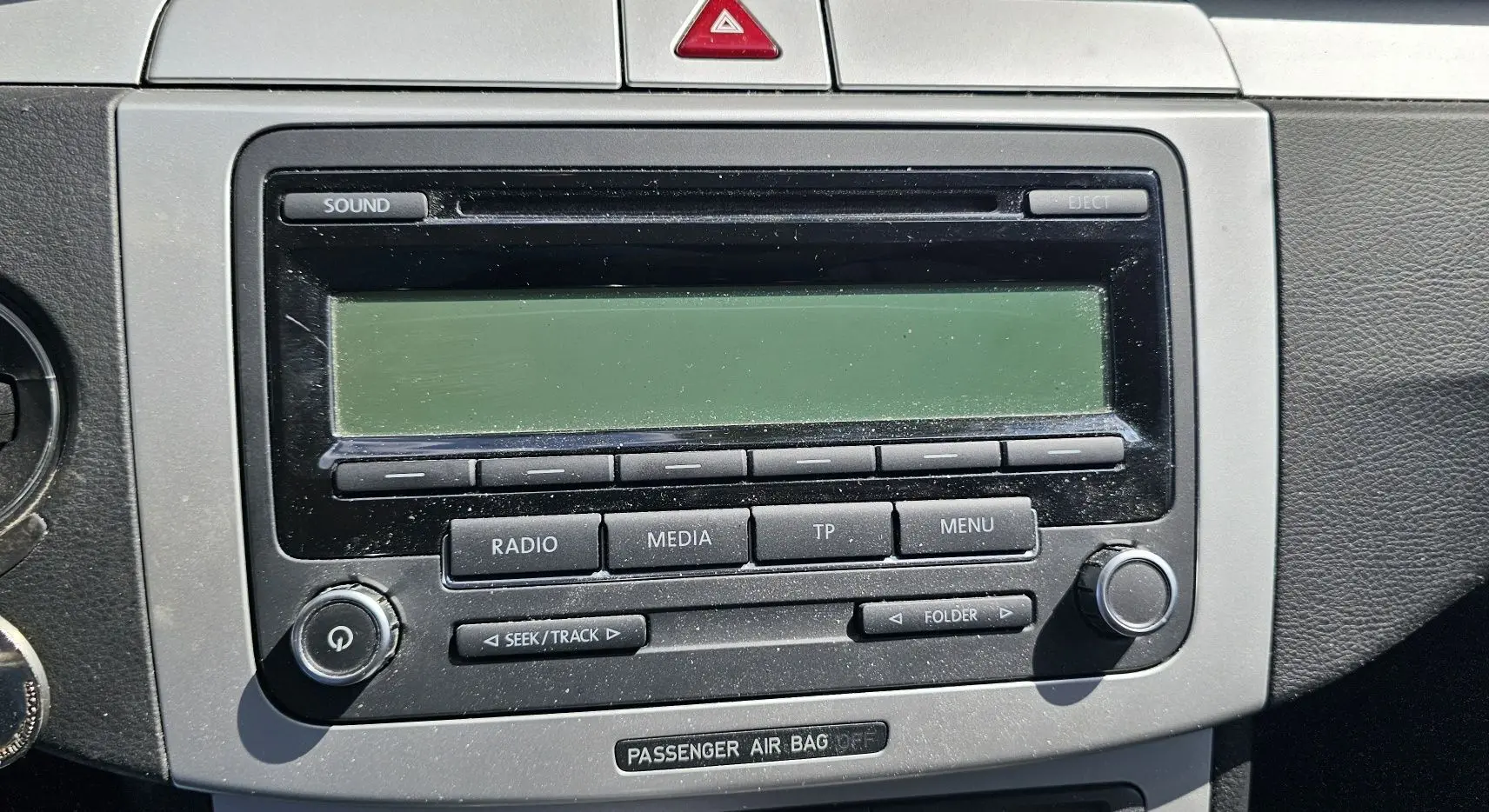 Gros plan sur la console centrale de la Volkswagen Passat 2009, montrant l'autoradio et la clé de contact insérée.