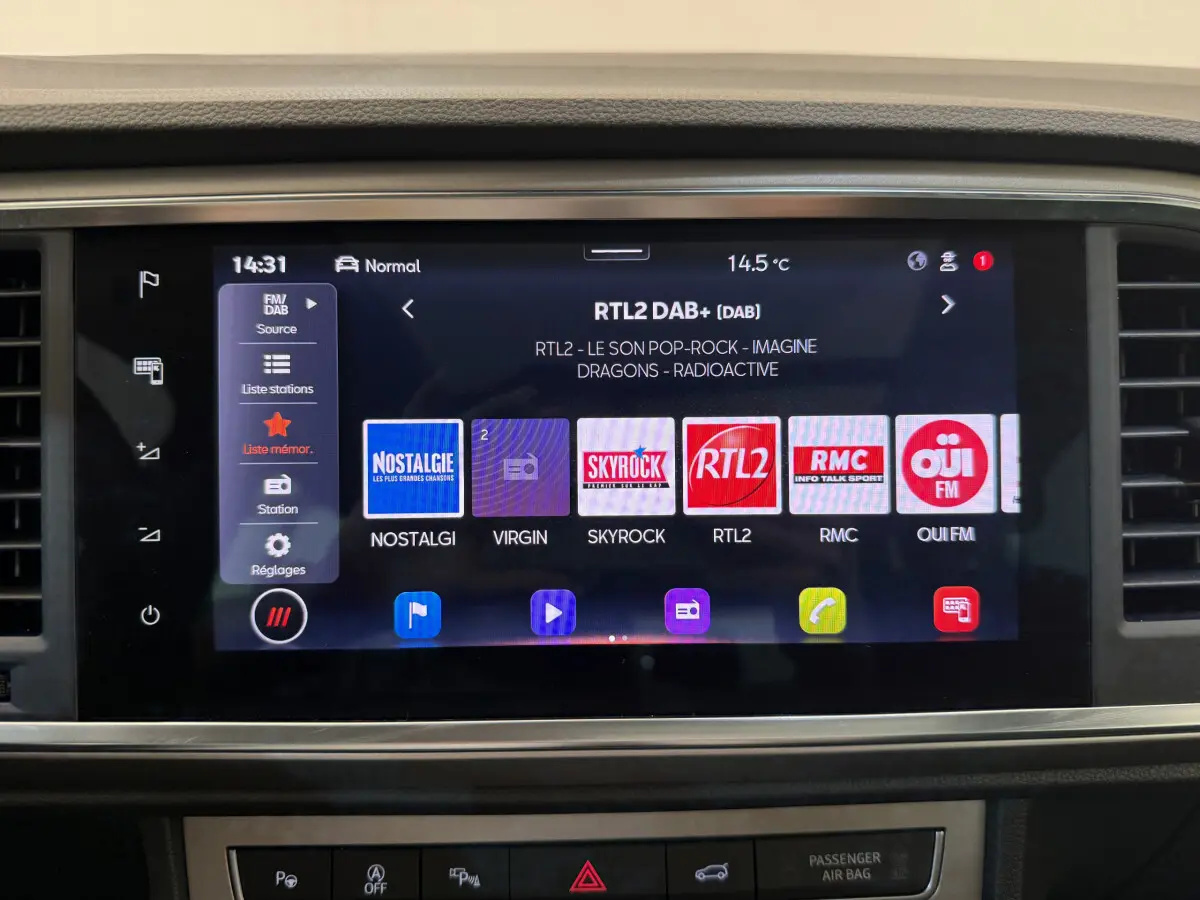 Écran tactile central du tableau de bord du SEAT Ateca gris clair, affichant les stations radio numériques.