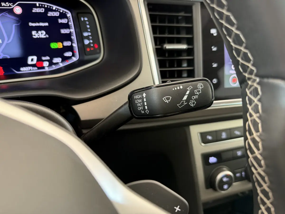 Gros plan sur la commande d’essuie-glace à gauche du volant dans l’habitacle du SEAT Ateca gris clair 2023.