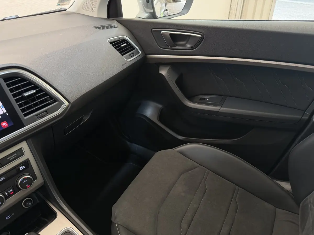 Vue intérieure côté passager du tableau de bord et siège noir du SEAT Ateca 2023 avec finitions modernes et écran tactile.